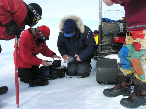 Team members gather to inspect and collect a meteorite being placed in a Teflon bag. Photo credit: M. Keiding, 2007 Team members gather to inspect and collect a meteorite being placed in a Teflon bag. Photo credit: M. Keiding, 2007