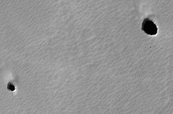 A pair of pit caves on Mars.  Could life exist inside? Credit: NASA/JPL/University of Arizona 