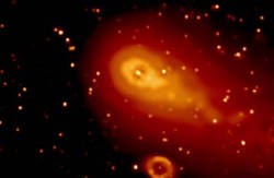Swift's Ultraviolet/Optical Telescope (UVOT) captured Comet 73P/Schwassmann-Wachmann 3's fragment C as it passed the famous Ring Nebula (oval, bottom) on May 7, 2006 (NASA)