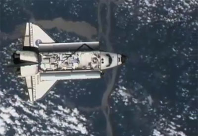 Atlantis cargo bay carrying spare parts for installation on the ISS with earth in the background. Credit: NASA