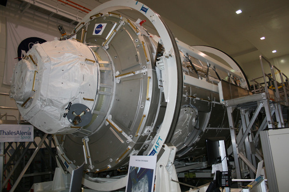 Side view of the Tranquility and Cupola modules which will be delivered to the ISS on the STS130 mission by shuttle Endeavour. The two modules combined weigh over 13.5 tons. Tranquility has six docking ports and is 7 meters (21 ft) in length and 4.5 meters (14.7 ft) in diameter with a pressurized volume of 75 cubic meters (2650 cubic ft). Credit: Ken Kremer