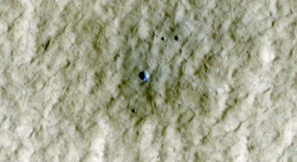 At the center of this view of an area of mid-latitude northern Mars, a fresh crater about 6 meters (20 feet) in diameter holds an exposure of bright material, blue in this false-color image. Image Credit: NASA/JPL-Caltech/University of Arizona