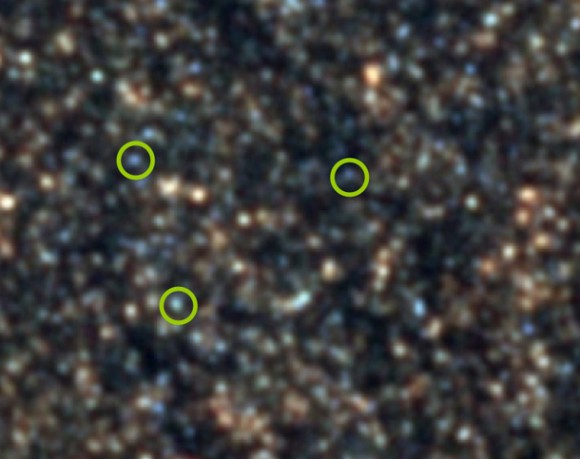 The Herschel-SPIRE image, where 3 examples of the new 'hot starbursts' glowing blue are circled. They appear faint because they are very distant, seen only 3 billion years after the Big Bang (credit: ESA/SPIRE/HerMES).