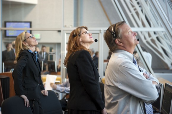 In Firing Room 4 of the Launch Control Center at NASA's Kennedy Space Center in Florida, NASA's Discovery Flow Director Stephanie Stilson, left, STS-133 Assistant Shuttle Launch Director and lead NASA Test Director Charlie Blackwell-Thompson and Shuttle Launch Director Mike Leinbach watch space shuttle Discovery blaze a trail of smoke and steam as it heads toward orbit on the STS-133 mission to the International Space Station. Credit: NASA