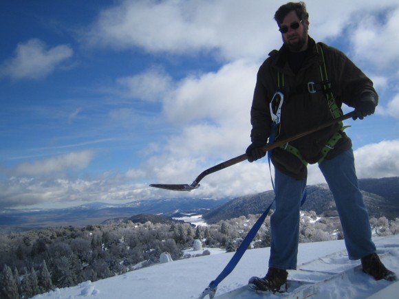 Astronomer Scott Kardel on top of the 200-inch Hale Telescope at the Palomar Observatory shoveling snow. Image courtesy Scott Kardel.
