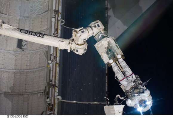 Anchored to a Canadarm2 mobile foot restraint, NASA astronaut Steve Bowen works outside the ISS during the second EVA of the STS-133 mission. Credit: NASA