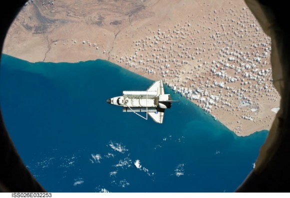 The space shuttle Discovery as seen from the International Space Station, flying over southwestern coast of Morocco in the northern Atlantic. During a post undocking fly-around, the crew members aboard the two spacecraft collected a series of photos of each other's vehicle. Credit: NASA