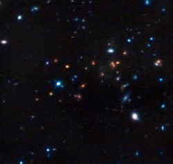 Hubble infrared image showing CL J1449+0856, the most distant mature cluster of galaxies found. Color data was added from ESO’s Very Large Telescope and the NAOJ’s Subaru Telescope. Credit: NASA, ESA, R. Gobat (Laboratoire AIM-Paris-Saclay, CEA/DSM-CNRS–)