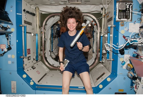 Cady Coleman, Expedition 26 flight engineer, is pictured near a Japanese-designed metal cylinder floating freely in the Destiny laboratory of the International Space Station while space shuttle Discovery remains docked with the station. On Feb. 28, spacewalkers Steve Bowen and Alvin Drew opened and 'filled' the cylinder, named "Message in a Bottle", with space, or rather the vacuum of outer space, and then sealed it to be brought back to Earth with the Discovery crew. Credit: NASA