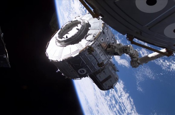July 15, 2001 – Canadarm2 performs its first official task, attaching the Quest Airlock to the Unity module of the International Space Station during Shuttle Mission STS-104. Credit: NASA