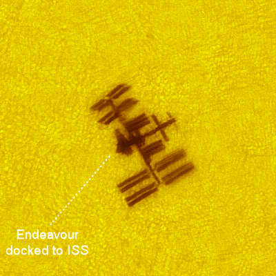 A close-up view of Endeavour and the ISS transiting the sun on May 25th from France. Transit duration was 0.5 seconds. Credit: Thierry Legault.