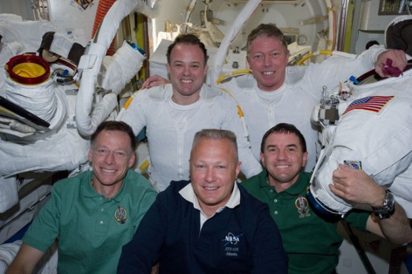Following the six-hour, 31-minute EVA, spacewalkers Ron Garan (top left) and Mike Fossum (top right), pose in the ISS’s Quest airlock with Chris Ferguson, STS-135 commander, Doug Hurley, pilot, and Rex Walheim, mission specialist. Credit: NASA