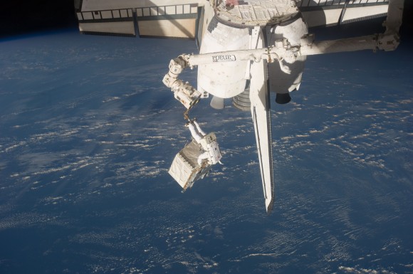 With space shuttle Atlantis docked to the space station for the STS-135 mission, the final EVA of the shuttle era took place on July 12, 2011. Here, Ron Garan is secured on a restraint on the space station remote manipulator system's robotic arm or Canadarm2, carrying a faulty pump module will be retuned to Earth by the shuttle. Credit: NASA