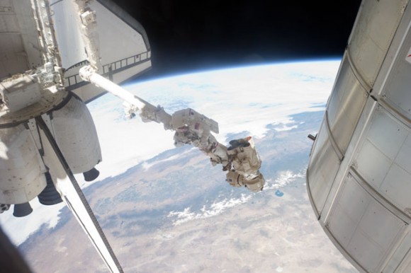 Suspended in a very unique position on the end of Canadarm2, Mike Fossum takes a picture during a July 12 spacewalk. Credit: NASA
