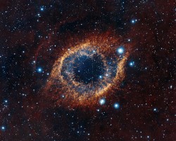 ESO's Visible and Infrared Survey Telescope for Astronomy (VISTA) has captured this unusual view of the Helix Nebula (NGC 7293), a planetary nebula located 700 light-years away. The coloured picture was created from images taken through Y, J and K infrared filters. While bringing to light a rich background of stars and galaxies, the telescope's infrared vision also reveals strands of cold nebular gas that are mostly obscured in visible images of the Helix.