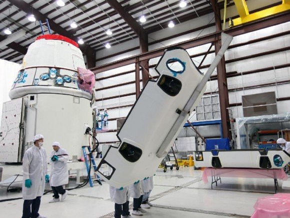 Workers lift a solar array fairing prior to installation on the company's Dragon spacecraft. The spacecraft will launch on the upcoming SpaceX CRS-2 mission. Credit: NASA/Kim Shiflett