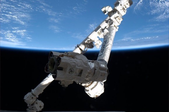 Canadarm pictured through a winow aboard the ISS will be used to grapple the SpaceX Dragon after planned March 1 liftoff. Credit: NASA/Thomas Mashburn