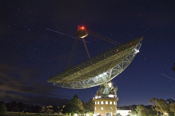 Space Shuttle Atlantis passes behind the Parkes radio telescope after final undocking from the International Space Station in July 2011. (Image Copyright: John Sarkissian; used with permission).