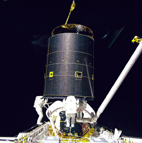 Three astronauts grab the Intelsat VI satellite during the STS-49 mission. Credit: NASA