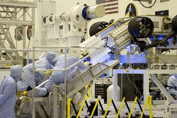 Engineers perform a fit check of the MMRTG on Curiousity at the Kennedy Space Center. The final installation of the MMRTG occured the evening prior to launch. (Credit: NASA/Cory Huston).