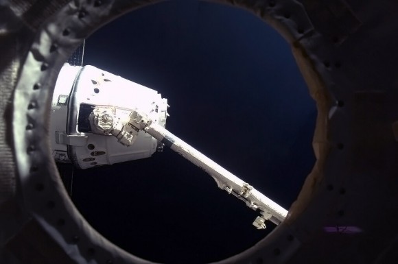 'Success! Canadarm2 holds Dragon by the nose, to drag it up and hook it on to a Station hatch.' Credit: NASA/Chris Hadfield.