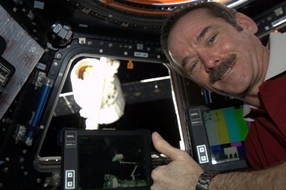 'Happy crewmember - Dragon securely snared by Canadarm2, ready to be lifted around, hooked into place, and opened up.' Credit: NASA/Chris Hadfield.