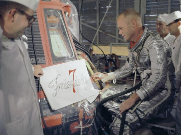 Astronaut John Glenn views stencilling used as a model to paint the words "Friendship 7" on his spacecraft. Credit: NASA