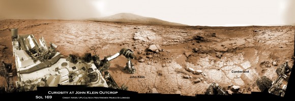 Panoramic view of Yellowknife Bay basin back dropped by Mount Sharp shows the location of the first two drill sites - John Klein & Cumberland - targeted by NASA’s Curiosity Mars rover. Curiosity accomplished historic 1st drilling into Martian rock at John Klein outcrop on Feb 8, 2013 (Sol 182) near where the robotic arm is touching the surface. This week the rover scooted about 9 feet to the right to Cumberland (right of center) for 2nd drill campaign in late-May 2013. Credit: NASA/JPL-Caltech/Ken Kremer/Marco Di Lorenzo