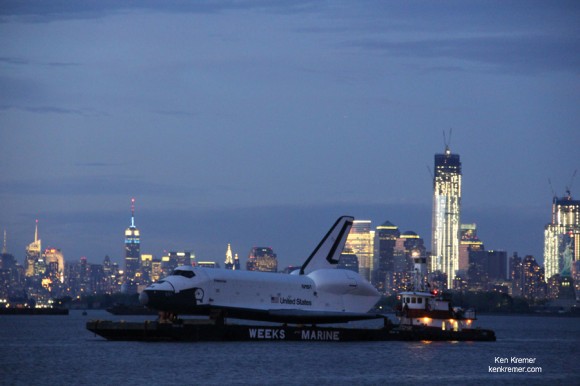 NASA’s real life Space Shuttle Enterprise transits the NYC Skyline at Dusk on a barge on June 3, 2012 during a two stage seagoing journey to her permanent new home at the Intrepid Sea, Air and Space Museum. Enterprise is bracketed by the Empire State Building, The Freedom Tower (still under construction) and the torch lit Statue of Liberty. Credit: Ken Kremer
