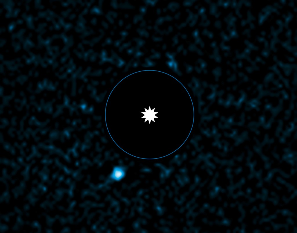 Planet HD95086 b is shown at lower left in this picture. Astronomers blocked out the light of the star (center) to image the exoplanet. The blue circle represents the equivalent orbit of Neptune in this star system. Credit: ESO/J. Rameau