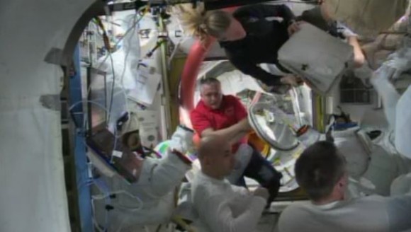 ISS Astronauts gather in the Quest airlock after water leaked inside Luca Parmitano's spacesuit. Via NASA TV.
