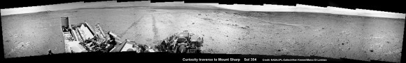 NASA’s Curiosity rover make tracks to Mount Sharp (at left) across the floor of Gale Crater. The rover paused to image the windblown ripple at right, below the hazy crater rim. The wheel tracks are about eight feet apart. This panoramic mosaic was assembled from a dozen navcam camera images taken on Sol 354 (Aug 4, 2013. Credit: NASA/JPL-Caltech/Ken Kremer Marco Di Lorenzo