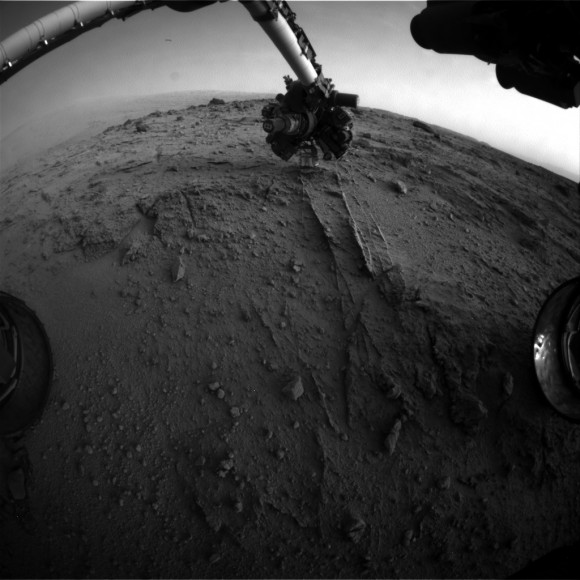 NASA's Mars rover Curiosity used a new technique, with added autonomy for the rover, in placement of the tool-bearing turret on its robotic arm during the 399th Martian day, or sol, of the mission. This image from the rover's front Hazard Avoidance Camera (Hazcam) on that sol shows the position of the turret during that process, with the Alpha Particle X-ray Spectrometer (APXS) instrument placed close to the target rock. Credit: NASA/JPL-Caltech