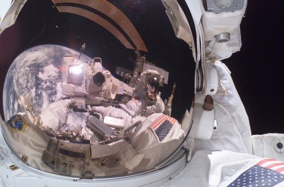 Mike Fossum, a mission specialist on STS-121, took this shot in July 2006. In the visor you can see space shuttle Discovery, part of the International Space Station and fellow crewmate Piers J. Sellers. Credit: NASA