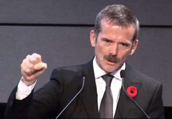Former Canadian astronaut Chris Hadfield was on hand for the official circulation ceremony of Canada's new space-themed $5 bill on Nov. 7, 2013. The press conference took place in two locations; Hadfield was at the Canadian Space Agency headquarters near Montreal, Que. The red flower on his lapel is a poppy for Remembrance Day, a Nov. 11 commemoration of veterans. Credit: Bank of Canada (webcast/screenshot)