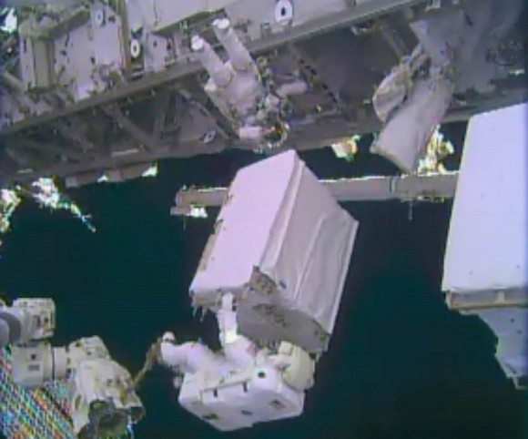 NASA astronaut Mike Hopkins holds a spare ammonia pump module during a spacewalk Dec. 24, 2013. Hopkins and fellow Expedition 38 Rick Mastracchio (top) performed two spacewalks to replace a pump blamed for crippling one of the International Space Station's two cooling loops Dec. 11. Credit: NASA TV (screenshot)