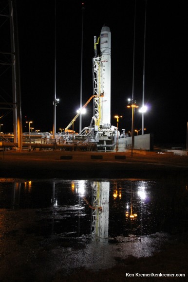 Antares rocket the night before launch beautifully reflected in icy water at NASA Wallops launch pad amidst bone chilling cold during remote camera setup for the photos featured herein. Credit: Ken Kremer - kenkremer.com