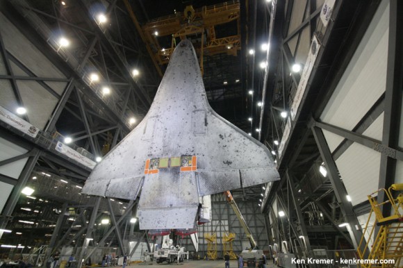 Full belly view of Space Shuttle Discovery coated with thousands of protective heat shield tiles in the transfer aisle of the VAB where it was processed for final launch on STS-133 mission. Note two rectangular attach points holding left and right side main separation bolts. Credit: Ken Kremer - kenkremer.com