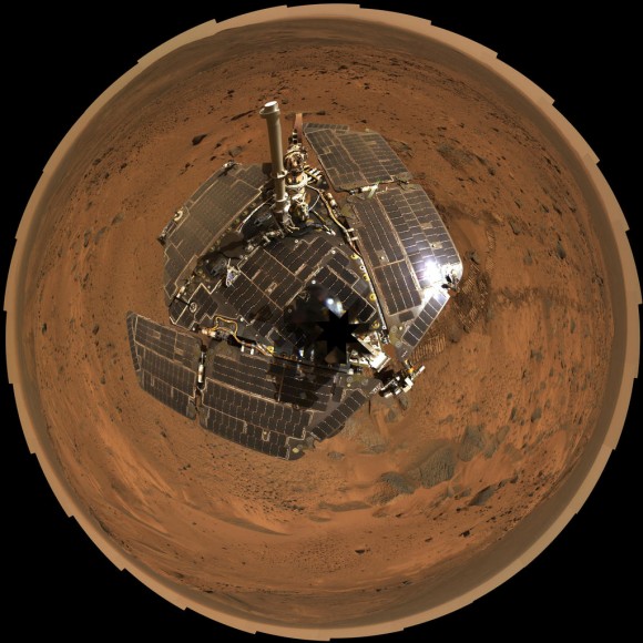 This bird's-eye view from August 2005 combines a self-portrait of the spacecraft deck and a panoramic mosaic of the Martian surface as viewed by NASA's Mars Exploration Rover Spirit. The rover's solar panels are still gleaming in the sunlight, having acquired only a thin veneer of dust two years after the rover landed and commenced exploring the red planet. Spirit captured this 360-degree panorama on the summit of "Husband Hill" inside Mars' Gusev Crater. During the period from Spirit's Martian days, or sols, 583 to 586 (Aug. 24 to 27, 2005), the rover's panoramic camera acquired the hundreds of individual frames for this largest panorama ever photographed by Spirit. Credit: NASA/JPL-Caltech/Cornell