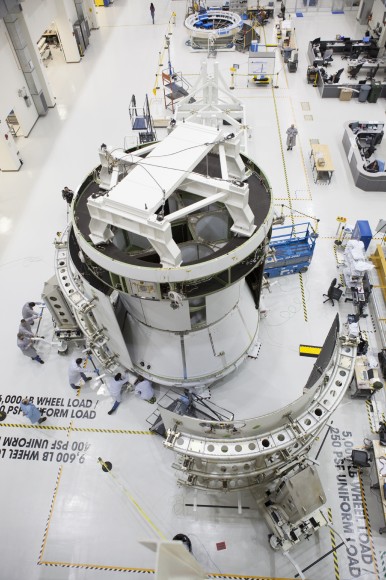 The fairings that will protect it during launch are added to Orion’s service module at the Operations and Checkout facility at Kennedy Space Center. Credit: NASA