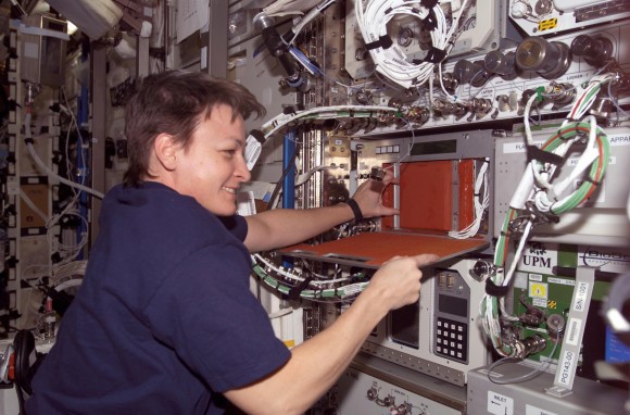 NASA astronaut Peggy Whitson working at the Plant Generic Bioprocessing Apparatus during Expedition 5 on the International Space Station in 2002. The experiment "monitored and maintained light, temperature, humidity and oxygen levels", NASA stated, to look at the production of lignin (a polymer) in plants. Credit: NASA