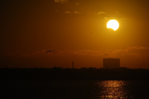 The 2013 partial eclipse rising over the Vehicle Assembly Building along the Florida Space Coast. This month's solar eclipse will offer comparable sunset views for eastern Australia. Photo by author.