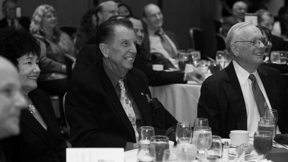 Jay Barbree and Neil Armstrong enjoy dinner with America’s first in orbit, John Glenn, who is performing standup comedy out of the picture. Courtesy: Jay Barbee. See Jay Barbree and Neil Armstrong enjoy dinner with America’s first in orbit, John Glenn, who is performing standup comedy out of the picture. Courtesy: Jay Barbree. See p. XIX