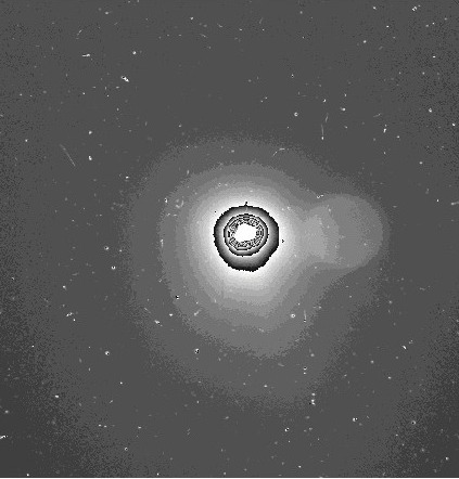 The coma of Rosetta's target comet as seen with the OSIRIS wide-angle camera. The image spans 150 km and was taken on 25 July 2014 with an exposure time of 330 seconds. The greyscale relates to the particle density in the coma, with highest density close to the nucleus, becoming more diffuse further away. The hazy circular structure on the right is an artefact. The nucleus is also overexposured. The specks and the streaks in the background are attributed to background stars and cosmic rays. Credits: ESA/Rosetta/MPS for OSIRIS Team MPS/UPD/LAM/IAA/SSO/INTA/UPM/DASP/IDA