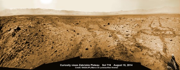 Curiosity rover looks back to the rocky plains of the Zabriskie plateau from sandy ramp into ‘Hidden Valley’ with 4th drill site target at ‘Bonanza King’ rock outcrop as shown in this photo mosaic view captured on Aug. 14, 2014, Sol 719. Sharp edged rocks at Zabriskie tore new holes into rover wheels. Navcam camera raw images stitched and colorized. Credit: NASA/JPL-Caltech/Marco Di Lorenzo/Ken Kremer-kenkremer.com