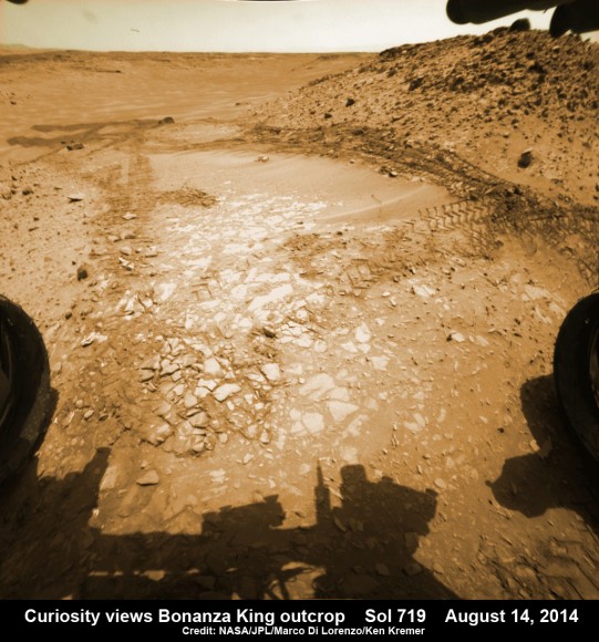Curiosity rover up close view of ‘Bonanza King’ rock outcrop and 4th drill target looking down from ramp and back into ‘Hidden Valley’ and hazardous dune field of sandy ripples on Aug. 14, 2014, Sol 719. Wheel tracks show where Curiosity drove into the valley, and back out again, earlier in August 2014. The largest of the individual flat rocks in the foreground are a few inches (several centimeters) across. Hazcam camera raw image flattened and colorized. Credit: NASA/JPL-Caltech/Marco Di Lorenzo/Ken Kremer - kenkremer.com