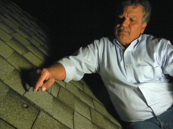 The impact dent on the rooftop of the Webber home in Novato. Luis Rivera points to the dent. (Image Credit, P.Jenniskens, L.Rivera, cams.seti.org)