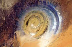 The Richat Structure in Mauritania, also known as the Eye of the Sahara, is a landmark for astronauts. It's hard to know where you are, especially if you're over a vast 3,600,000-square-mile desert, but this bull's-eye orients you, instantly. Oddly, it appears not to be the scar of a meteorite but a deeply eroded dome, with a rainbow-inspired color scheme. Image Credit: Chris Hadfield / NASA