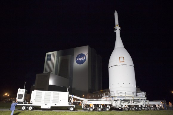 At NASA's Kennedy Space Center in Florida, the agency's Orion spacecraft pauses in front of the spaceport's iconic Vehicle Assembly Building as it is transported to Launch Complex 37 at Cape Canaveral Air Force Station. After arrival at the launch pad, United Launch Alliance engineers and technicians will lift Orion and mount it atop its Delta IV Heavy rocket. Credit:   NASA/Frankie Martin 