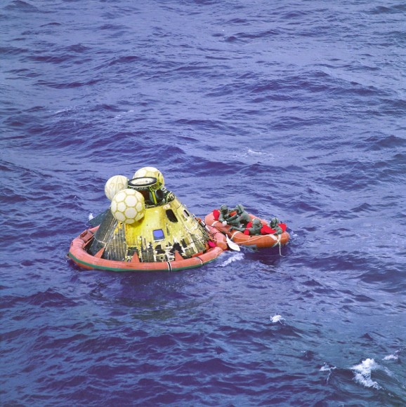 Apollo 11 Comes Home. The Apollo 11 crew await pickup by a helicopter from the USS Hornet, prime recovery ship for the historic lunar landing mission. The fourth man in the life raft is a United States Navy underwater demolition team swimmer. All four men are wearing biological isolation garments. The splashed down at 12:49 a.m. EDT, July 24, 1969, about 812 nautical miles southwest of Hawaii and only 12 nautical miles from the USS Hornet. Credit: NASA